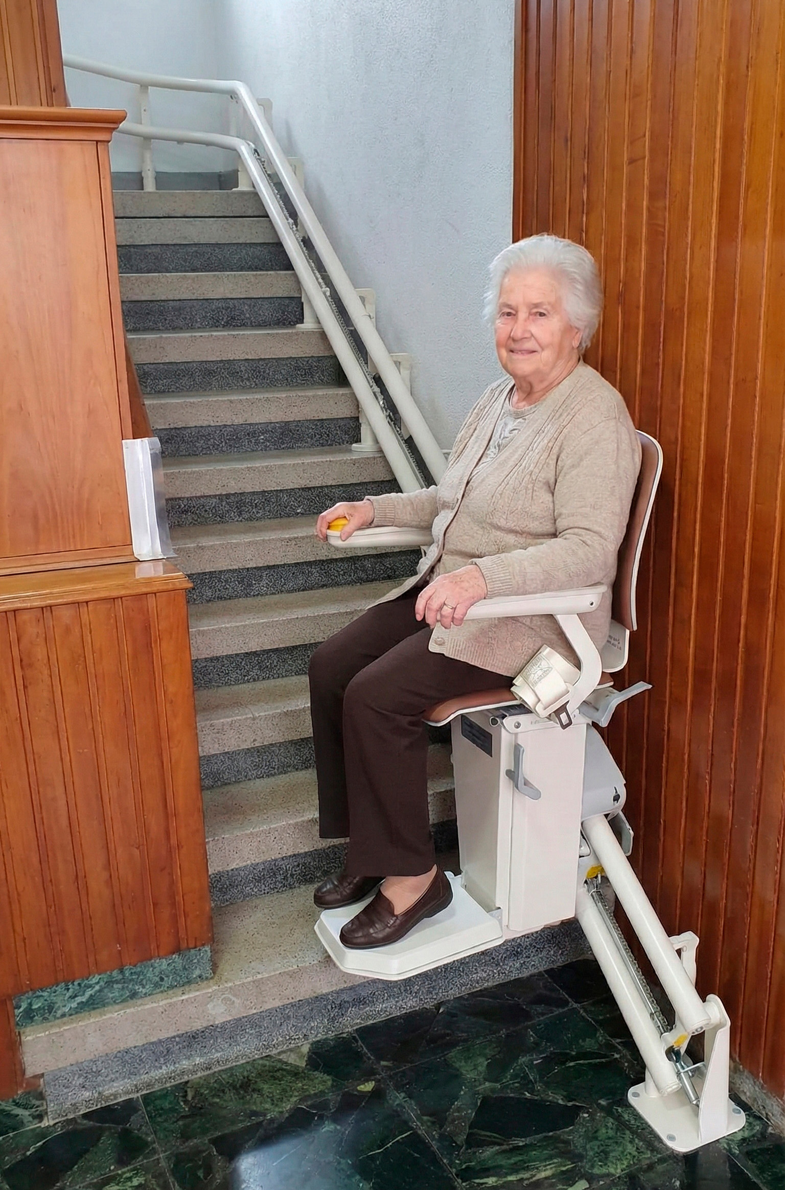 Señora usando silla salvaescaleras de tramo curvo